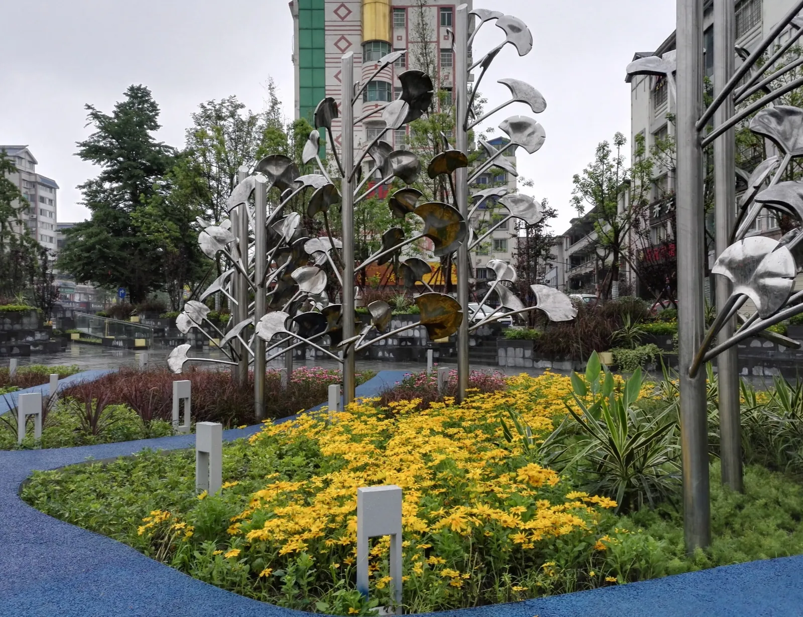 Ginkgo sculptures around a planted bed in the plaza