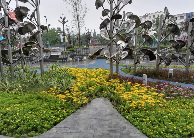 Silver ginkgo sculpture trees with yellow planting in front